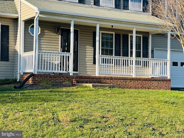 entrance to property featuring a lawn and covered porch