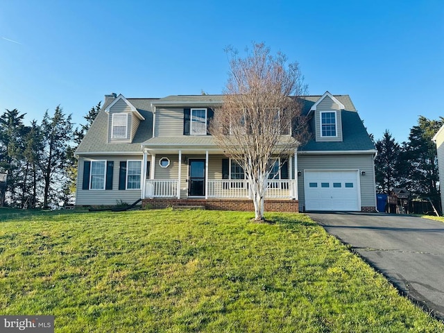 traditional home featuring an attached garage, covered porch, aphalt driveway, and a front yard