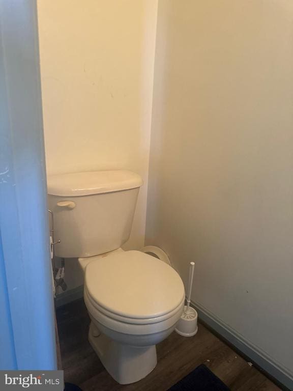bathroom with baseboards, toilet, and wood finished floors