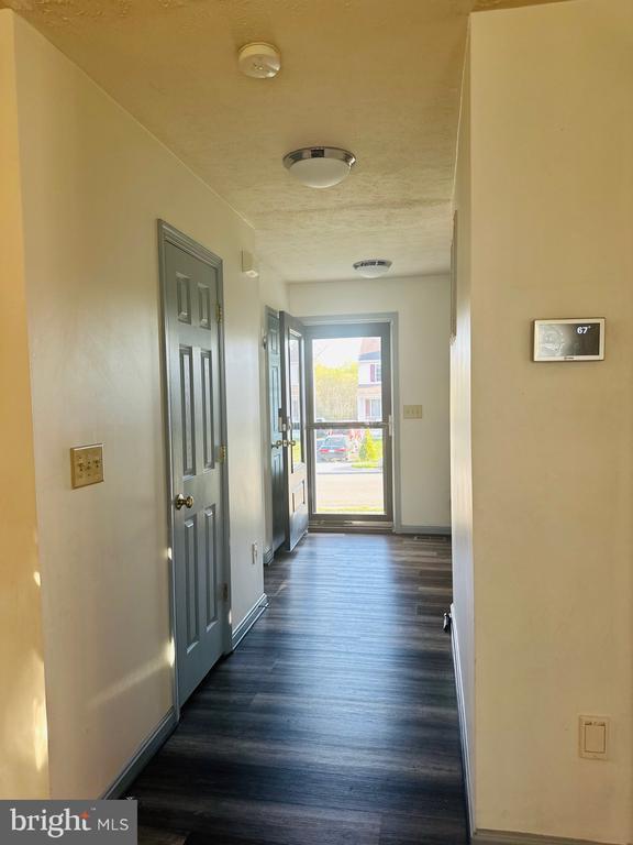 hall featuring baseboards and dark wood finished floors