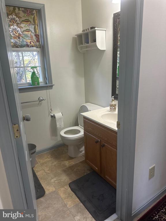 bathroom featuring stone finish floor, toilet, and vanity