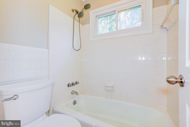  - bathroom with tile walls, tub / shower combination, and wainscoting