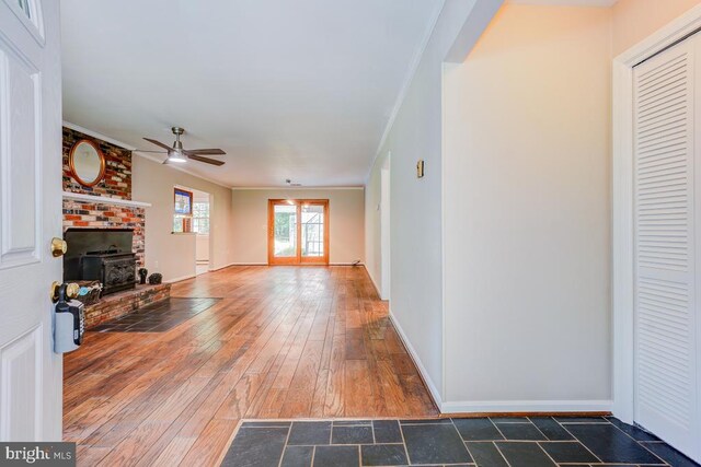  - unfurnished living room featuring ceiling fan, crown molding, a brick fireplace, and hardwood / wood-style flooring
