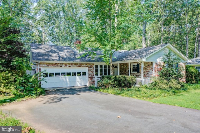  - single story home featuring asphalt driveway, covered porch, a garage, a chimney, and brick siding