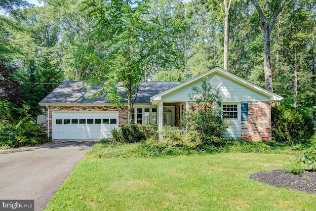  - single story home featuring driveway, an attached garage, brick siding, and a front yard