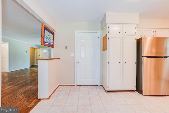  - kitchen featuring freestanding refrigerator, white cabinetry, light wood finished floors, and open floor plan