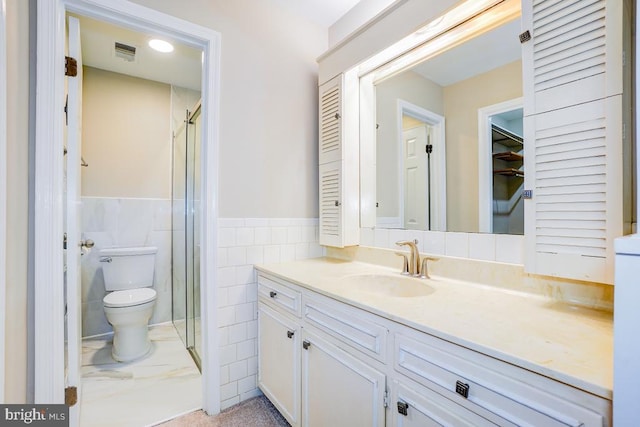  - bathroom with vanity, a shower stall, tile walls, and a wainscoted wall