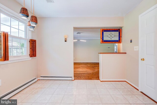  - unfurnished room with baseboard heating, a baseboard radiator, and tile patterned floors