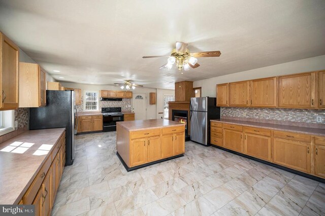 8128 Shirley Rd, Spotsylvania, VA 22551 - kitchen with black electric range oven, freestanding refrigerator, a lit fireplace, and a ceiling fan
