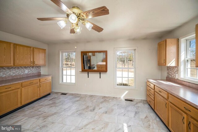 8128 Shirley Rd, Spotsylvania, VA 22551 - kitchen featuring backsplash, ceiling fan, baseboards, light countertops, and light marble finish flooring