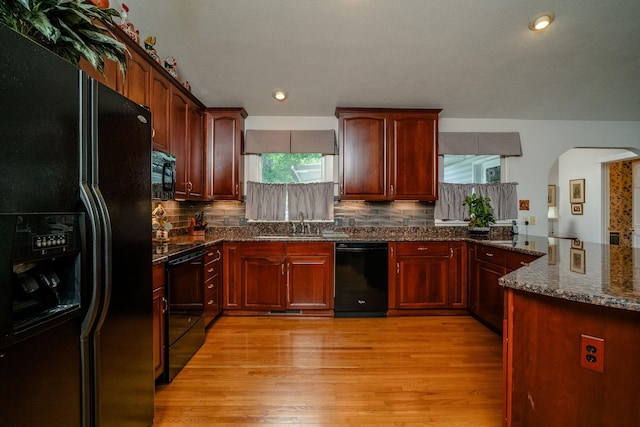 16540 Stoney Lea Ln, Elkton, VA 22827 - kitchen featuring black appliances, arched walkways, light wood finished floors, backsplash, and dark stone countertops