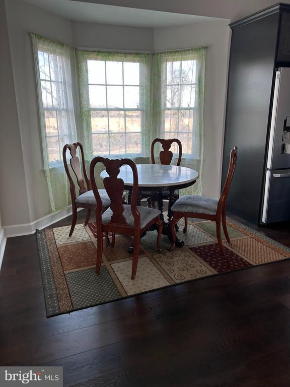 - dining space with baseboards and dark wood finished floors