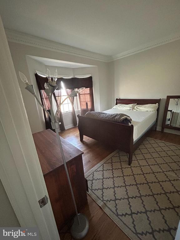  - bedroom with wood finished floors and crown molding