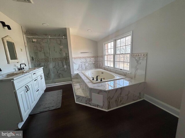  - bathroom featuring vanity, a marble finish shower, a garden tub, vaulted ceiling, and wood finished floors