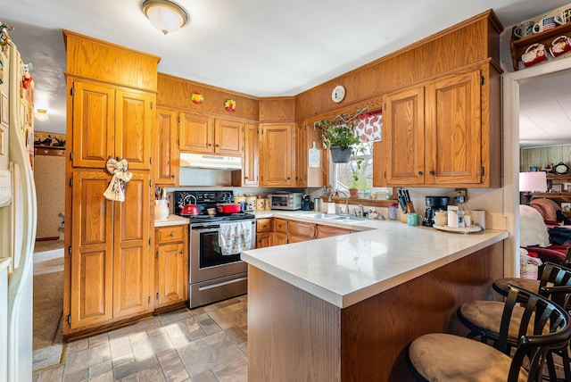 14335 S E Side Hwy, Grottoes, VA 24441 - kitchen featuring a sink, a peninsula, a breakfast bar, light countertops, and electric stove