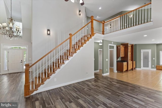 8606 Laroque Run Dr, Fredericksburg, VA 22407 - unfurnished living room featuring wood finished floors, stairway, baseboards, and a towering ceiling