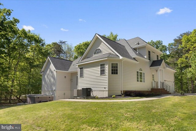 8606 Laroque Run Dr, Fredericksburg, VA 22407 - back of property with a yard, central AC, a hot tub, and a shingled roof