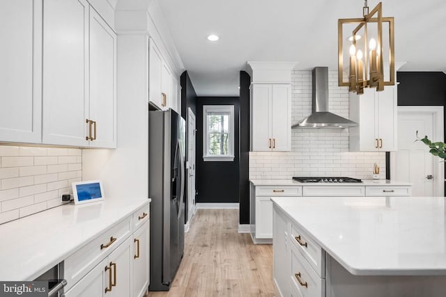 11302 Radcliff Ter, Spotsylvania, VA 22551 - kitchen with wall chimney range hood, appliances with stainless steel finishes, light wood-type flooring, white cabinetry, and decorative backsplash