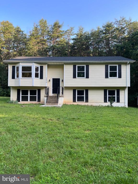 10214 Unique Trl, Rixeyville, VA 22737 - bi-level home featuring a front lawn and view of wooded area