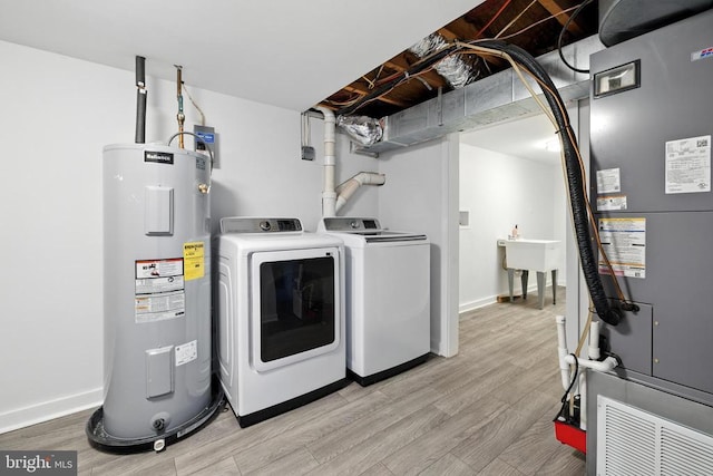 6 Charles St, Luray, VA 22835 - laundry room with water heater, washer and dryer, light wood-style flooring, and heating unit