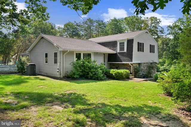  - tri-level home with a front lawn, stone siding, and roof with shingles