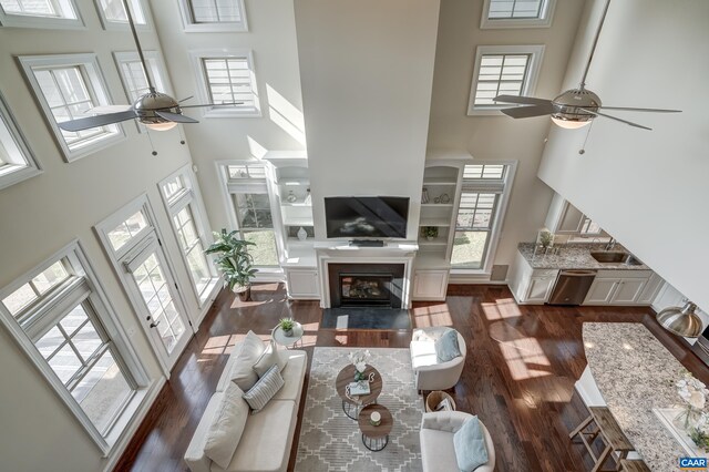 804 Golf View Dr, Crozet, VA 22932 - living area with dark wood-style flooring, a healthy amount of sunlight, ceiling fan, a fireplace with flush hearth, and a towering ceiling
