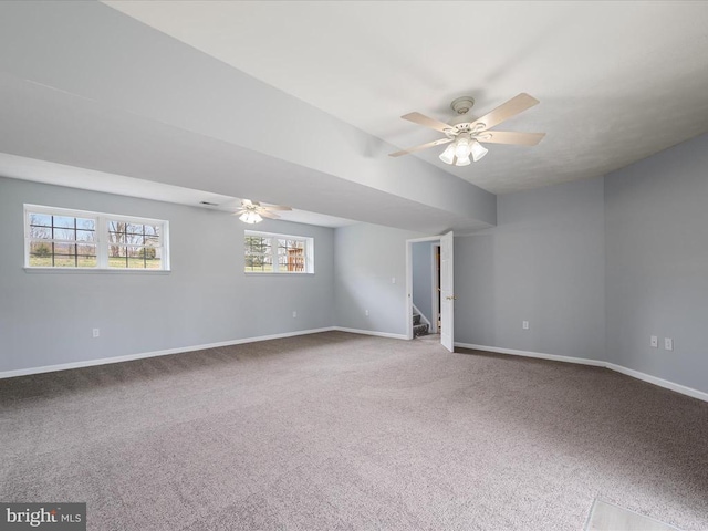 empty room featuring stairway, ceiling fan, carpet flooring, and baseboards