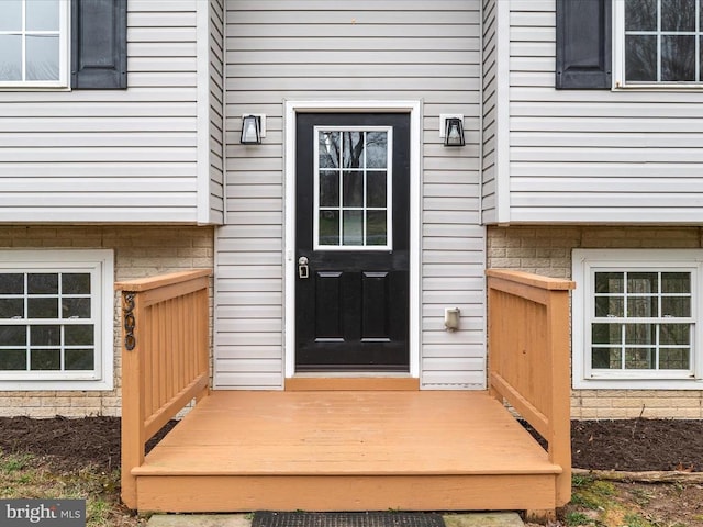 view of exterior entry with a wooden deck