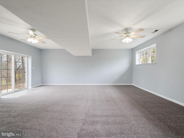 carpeted empty room featuring baseboards, a ceiling fan, and visible vents