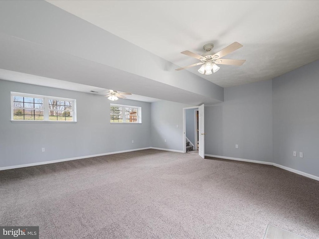 carpeted spare room featuring stairway, baseboards, and a ceiling fan