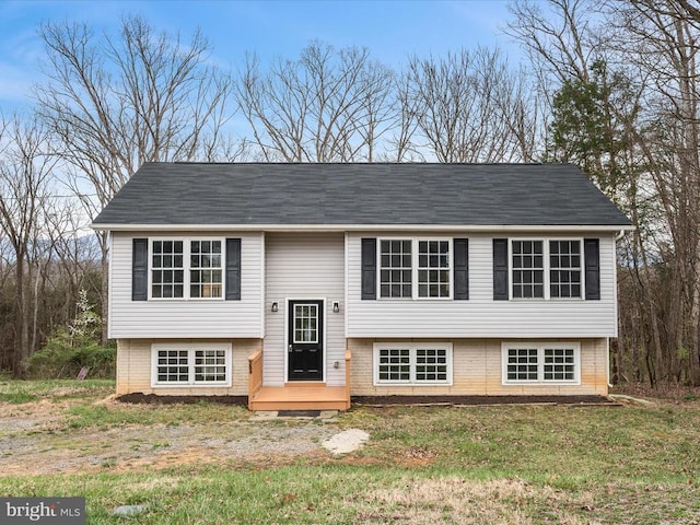 bi-level home with brick siding and a front lawn