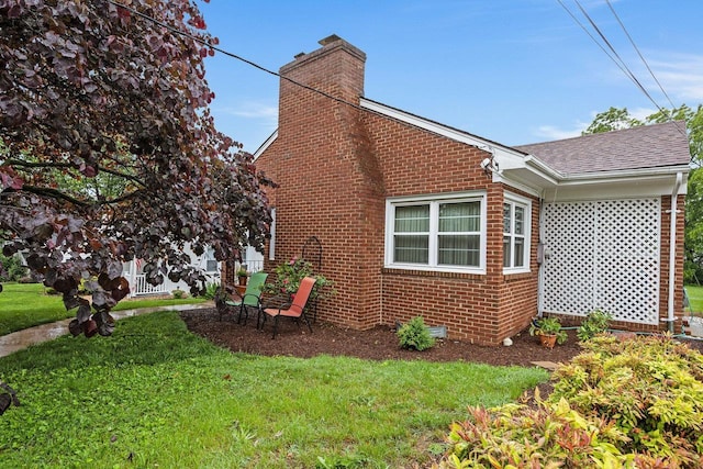 1435 Bluestone St, Harrisonburg, VA 22801 - view of home's exterior with brick siding, a chimney, a yard, and a shingled roof