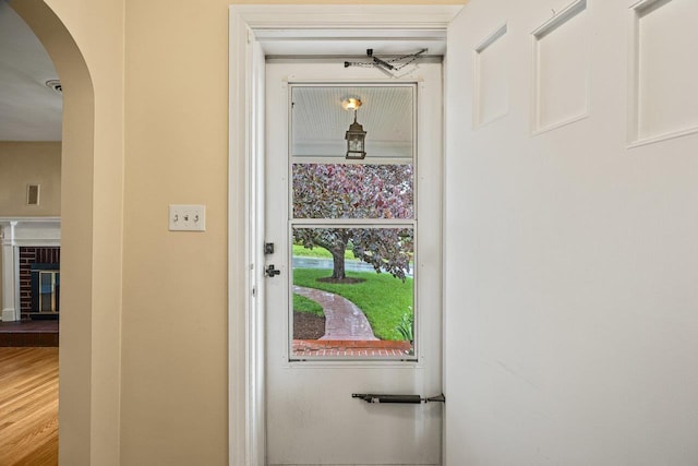 1435 Bluestone St, Harrisonburg, VA 22801 - doorway to outside with arched walkways, a fireplace, and wood finished floors