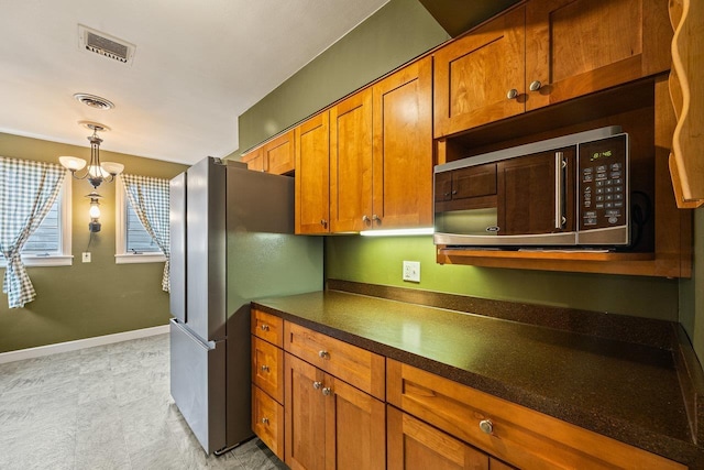 1435 Bluestone St, Harrisonburg, VA 22801 - kitchen featuring stainless steel appliances, dark countertops, brown cabinetry, decorative light fixtures, and baseboards