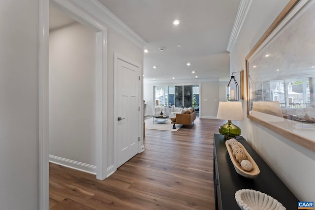hallway with crown molding, wood finished floors, baseboards, and recessed lighting