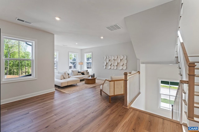 living area featuring baseboards, hardwood / wood-style floors, and visible vents