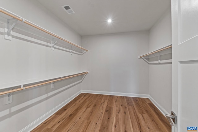 walk in closet with visible vents and wood finished floors