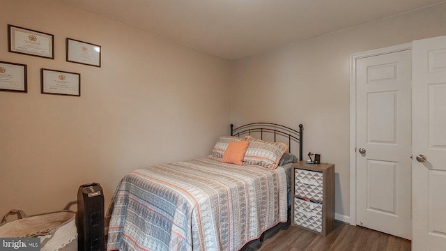 bedroom with baseboards and wood finished floors