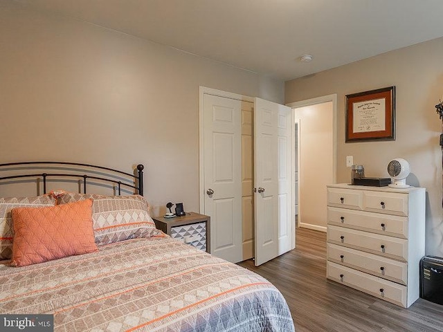bedroom with baseboards and dark wood-type flooring