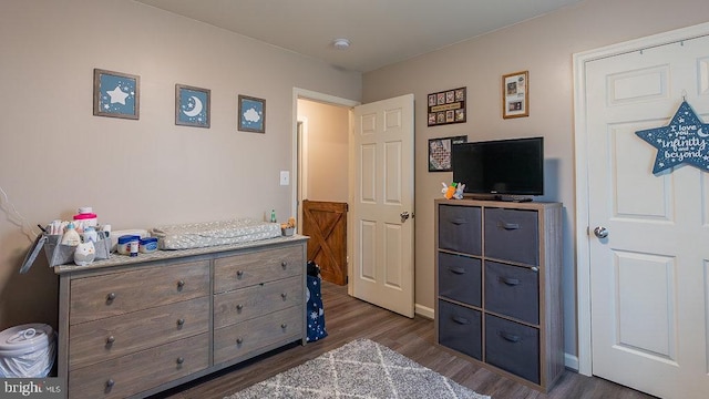 bedroom with baseboards and dark wood-type flooring