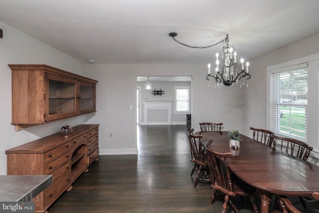 dining area with dark wood-style floors, baseboards, and a chandelier