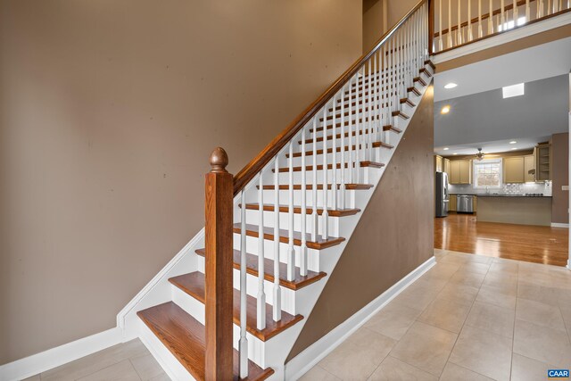 staircase featuring tile patterned flooring, baseboards, a ceiling fan, and recessed lighting
