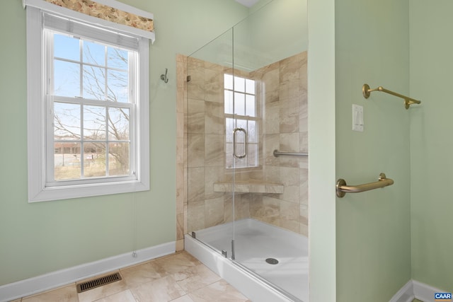 bathroom with plenty of natural light, visible vents, baseboards, and a shower stall