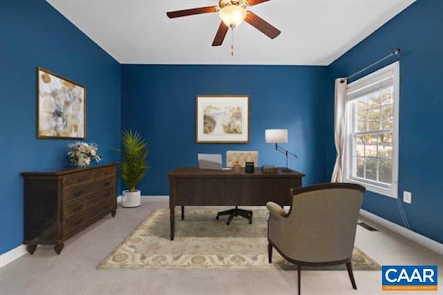 home office with a ceiling fan, baseboards, and carpet