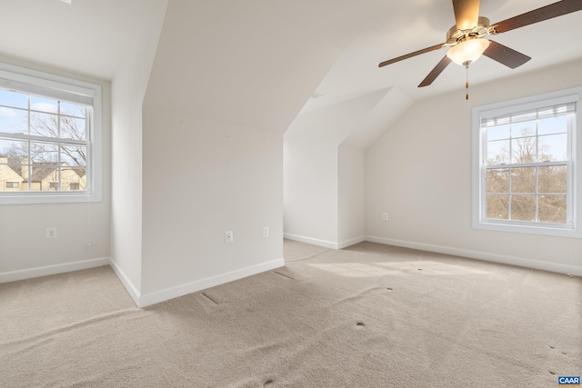 bonus room featuring light carpet, a wealth of natural light, and baseboards