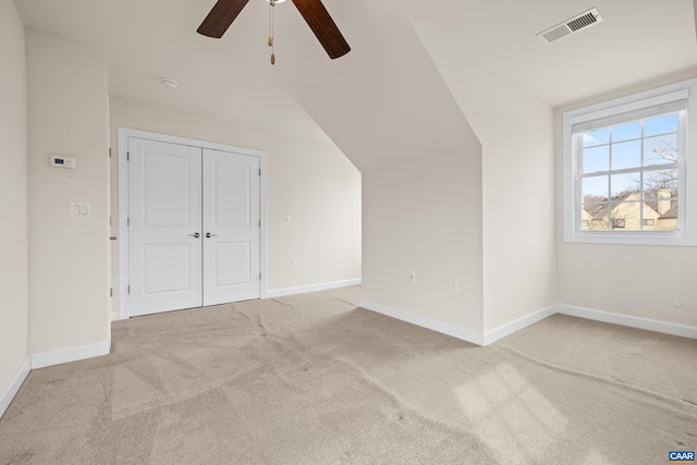 additional living space featuring carpet, visible vents, baseboards, ceiling fan, and lofted ceiling