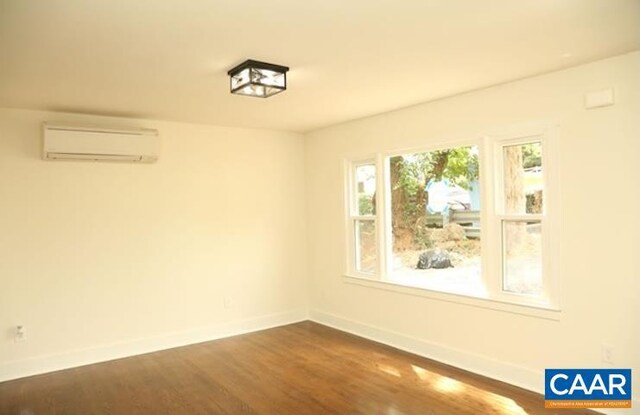 2228 Center Ave, Charlottesville, VA 22903 - unfurnished room featuring a wall mounted air conditioner, dark wood-style flooring, and baseboards