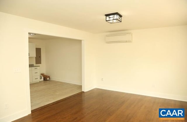 2228 Center Ave, Charlottesville, VA 22903 - spare room with baseboards, a wall mounted AC, and dark wood-type flooring