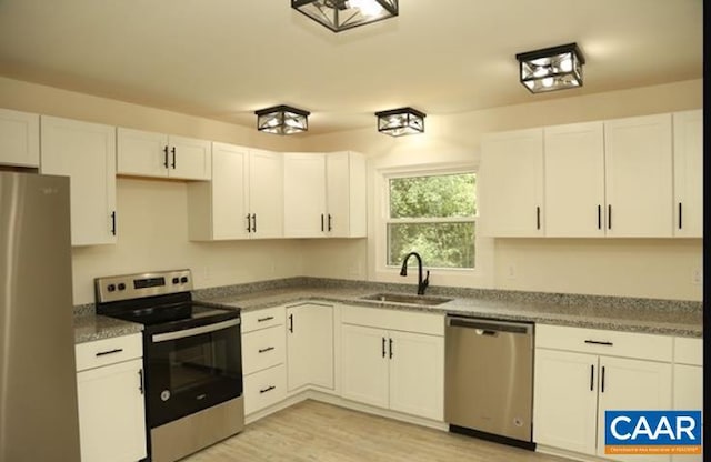 2228 Center Ave, Charlottesville, VA 22903 - kitchen with white cabinetry, light wood-style floors, stainless steel appliances, and a sink