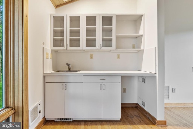  - bar area featuring a sink and light wood-style floors